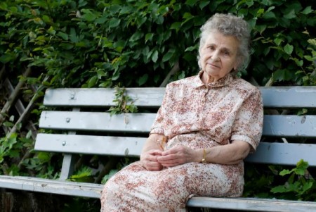 older-woman-on-bench-looking-sad