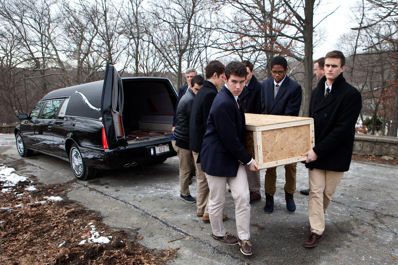 Brendan McInerney (front, from left), Noah Piou, Emmett Dalton and their fellow students from Roxbury Latin boys' school carry the casket of a man who was left unclaimed by family to a grave site in Fairview Cemetery on Friday.