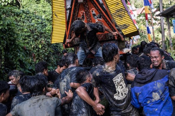People carry the coffin of Liling Saalino as a part of the Rambu Solo ceremony. When a person dies, pigs, chickens and buffalo are sacrificed, as the locals believe that the animals carry the soul of the deceased into heaven. The number and type of animals killed reflect the social status of the dead person.