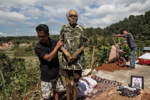 A man holds the corpse of Tang Diasik, who died six years ago, as he dries the corpse during the Ma’Nene ritual in Ba’Tan village, Toraja, South Sulawesi, Indonesia.
